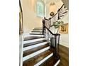 Detailed staircase with decorative iron railing and wood steps leads to the upper level and natural lighting at 3938 Hillsman Ln, Marietta, GA 30062