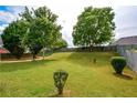 Expansive, lush backyard with mature trees and a wooden fence, perfect for outdoor activities at 4005 Brushymill Ct, Loganville, GA 30052