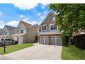 Well-maintained two-story home showcasing a two-car garage, lush lawn, and established landscaping in a suburban neighborhood at 5830 Sterling Ct, Cumming, GA 30040