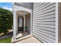 Inviting front porch with decorative columns, wood accents, a glass-paneled door, and lush greenery enhancing curb appeal at 5830 Sterling Ct, Cumming, GA 30040