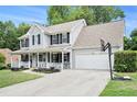 Two-story house featuring a covered front porch and an attached garage with basketball hoop at 10 Callaway Ct, Hiram, GA 30141