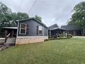 Beautiful home with dark siding, brick foundation, and a detached two-car garage with upstairs at 284 Harris Loop, Dallas, GA 30157