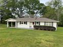 Inviting single-story home with a well-maintained lawn, white siding, and a convenient covered carport at 66 Lakeshore Dr, Bowdon, GA 30108