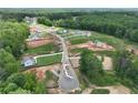 Overhead shot of a new neighborhood and community with beautiful wooded surrounding areas and gray asphalt roadways at 133 Prescott Manor Dr, Canton, GA 30115