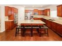 Spacious kitchen featuring cherry wood cabinets, stainless steel appliances, and an island with seating at 2405 Brisbane Dr, Conyers, GA 30013