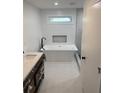 Bright bathroom with soaking tub, marble countertop, dark fixtures and recessed niche at 388 Sargent Se Dr, Atlanta, GA 30315