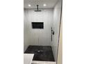 Shower featuring rainfall shower head, black and white marble tile, and recessed niche at 388 Sargent Se Dr, Atlanta, GA 30315