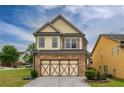 Lovely home featuring a stone-accented garage and neutral colored siding, set against a bright blue sky at 3637 Sweet Ashley Ln, Loganville, GA 30052