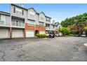 View of exterior of townhomes with garages and parking, surrounded by mature trees at 508 Vinings Forest Se Ct, Smyrna, GA 30080