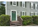 Up close view of home featuring a green front door, a small porch, and manicured hedges at 6420 Marbut Rd, Lithonia, GA 30058