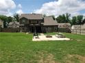 Large fenced backyard with green grass and a brick fire pit, perfect for outdoor entertaining at 70 Paladin Dr, Covington, GA 30016