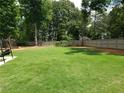 Expansive grassy backyard enclosed by a wood fence, offering ample space for recreation at 70 Paladin Dr, Covington, GA 30016