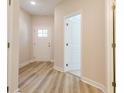 Hallway with wood-look flooring leading to a white front door with glass panels at 1991 Deco Dr, Kennesaw, GA 30144