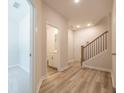 Hallway features wood-look flooring, a staircase with dark railings, and doorways to other rooms at 1991 Deco Dr, Kennesaw, GA 30144