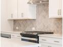 Bright kitchen showcasing white cabinets, stainless steel appliances, and elegant backsplash at 1991 Deco Dr, Kennesaw, GA 30144