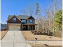 Charming two-story home with a brick and siding facade, covered entry and a two car garage at 5637 Valley Loop, Fairburn, GA 30213