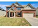 Attractive two-story home with brick facade, covered porch, and attached two-car garage at 385 Hinton Chase Pkwy, Covington, GA 30016