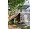 View of stacked stone and vinyl exterior with wooden staircase and small door at 3076 Quantum Ln, Atlanta, GA 30341