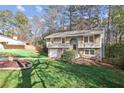 Well-maintained split-level home with stone accents, attached garage, and mature landscaping at 875 Waterbrook Ct, Roswell, GA 30076