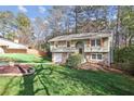 Charming two-story home featuring stone accents, wood shutters, and a well-manicured lawn at 875 Waterbrook Ct, Roswell, GA 30076