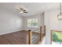 Second-floor living space features wood floors, ceiling fan, and railing overlooking entry at 875 Waterbrook Ct, Roswell, GA 30076