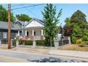 Charming white cottage-style home with a lush front yard, attractive fence, and welcoming porch at 69 Randolph Ne St, Atlanta, GA 30312