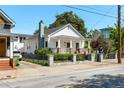 Exterior view of a white cottage-style house with a welcoming porch, well-kept lawn and paved driveway at 69 Randolph Ne St, Atlanta, GA 30312