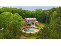 Expansive aerial view showcasing a brick home with an inviting pool area and surrounded by lush greenery at 1212 Lee Whatley Dr, Lithonia, GA 30058