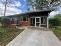 Quaint brick home featuring a screened-in porch and a long concrete driveway at 2069 Bixler Circle, Decatur, GA 30032