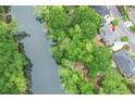 Stunning aerial view of waterfront property surrounded by mature trees and lush landscaping at 9175 Etching Overlook, Johns Creek, GA 30097