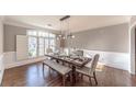 Elegant dining room featuring a farmhouse-style table, designer lighting, and hardwood floors at 9175 Etching Overlook, Johns Creek, GA 30097