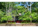 Elegant two-story home with a charming front porch, surrounded by mature trees and a green lawn at 30 Sessions Nw St, Marietta, GA 30060