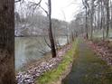 Scenic pathway beside a tranquil lake surrounded by bare trees and a dusting of snow at 8145 Stone Hill Rd, Cumming, GA 30028