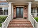 Close-up of the elegant double front doors, complemented by brick steps and stylish lighting fixtures at 1273 Promontory Ln, Marietta, GA 30062