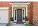 Charming front entrance with potted plants, coach lights, and a neutral-colored door at 4004 Edgecomb Dr, Roswell, GA 30075