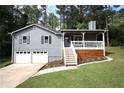 Charming home with gray siding, white trim, a front porch and an attached two-car garage at 443 Indian Hills Dr, Dallas, GA 30157