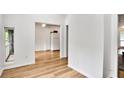 Hallway view leading to the kitchen, showcasing hardwood floors and ample natural light at 8740 Roswell Rd # 9C, Atlanta, GA 30350