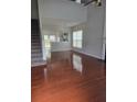 Bright living room with hardwood floors, large windows, and open layout leading to the kitchen at 1692 Woodsford Nw Rd, Kennesaw, GA 30152