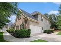 A lovely two-story home's side shows a spacious two-car garage and lush landscaping at 448 Cape Ivey Dr, Dacula, GA 30019