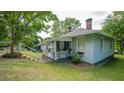 Quaint home featuring a lovely front porch, verdant lawn, and landscaped yard on a sunny day at 2881 Parrott Nw Ave, Atlanta, GA 30318