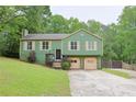 Charming two-story home with an attached two-car garage nestled amidst lush greenery at 3785 Willow Ridge Rd, Douglasville, GA 30135