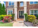 Elegant double front doors framed by columns and lush landscaping, creating a grand entrance at 305 Spooner Dr, Mcdonough, GA 30252