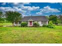 Inviting ranch-style home with a red front door, framed by lush landscaping on a spacious, green lawn at 2068 Hampton Locust Grove Rd, Locust Grove, GA 30248
