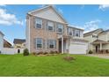 Charming two-story home featuring a brick and siding exterior, lush lawn, and attached two-car garage at 340 Paulownia Cir, Mcdonough, GA 30253