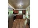 Functional kitchen with stainless steel refrigerator, wooden cabinets, and laminate countertops at 3739 Jamestown Ct, Doraville, GA 30340