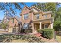 Beautiful brick home featuring a well-kept lawn, charming shutters, and an inviting front porch at 4840 Shiloh Springs Rd, Cumming, GA 30040
