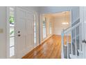 Bright foyer with hardwood floors, white trim and clear sightlines to dining room at 1912 Riverton Dr, Suwanee, GA 30024