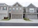 Townhome exterior showcasing the building's facade, garages, and well-maintained landscaping at 7621 Avalon Blvd, Fairburn, GA 30213