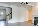 Bright living room with a fireplace, open staircase, and neutral color palette at 7621 Avalon Blvd, Fairburn, GA 30213