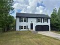 Charming two-story home with blue siding, black shutters and a spacious two-car garage at 1185 Jocelyn Ct, Stone Mountain, GA 30088